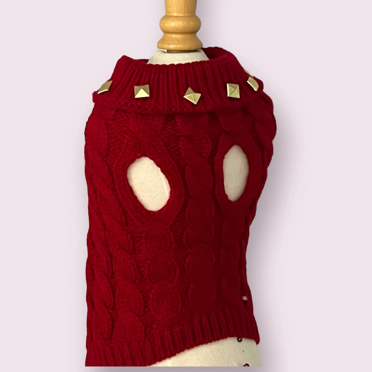 Red knitted dog sweater with gold studs on a mannequin against a white background