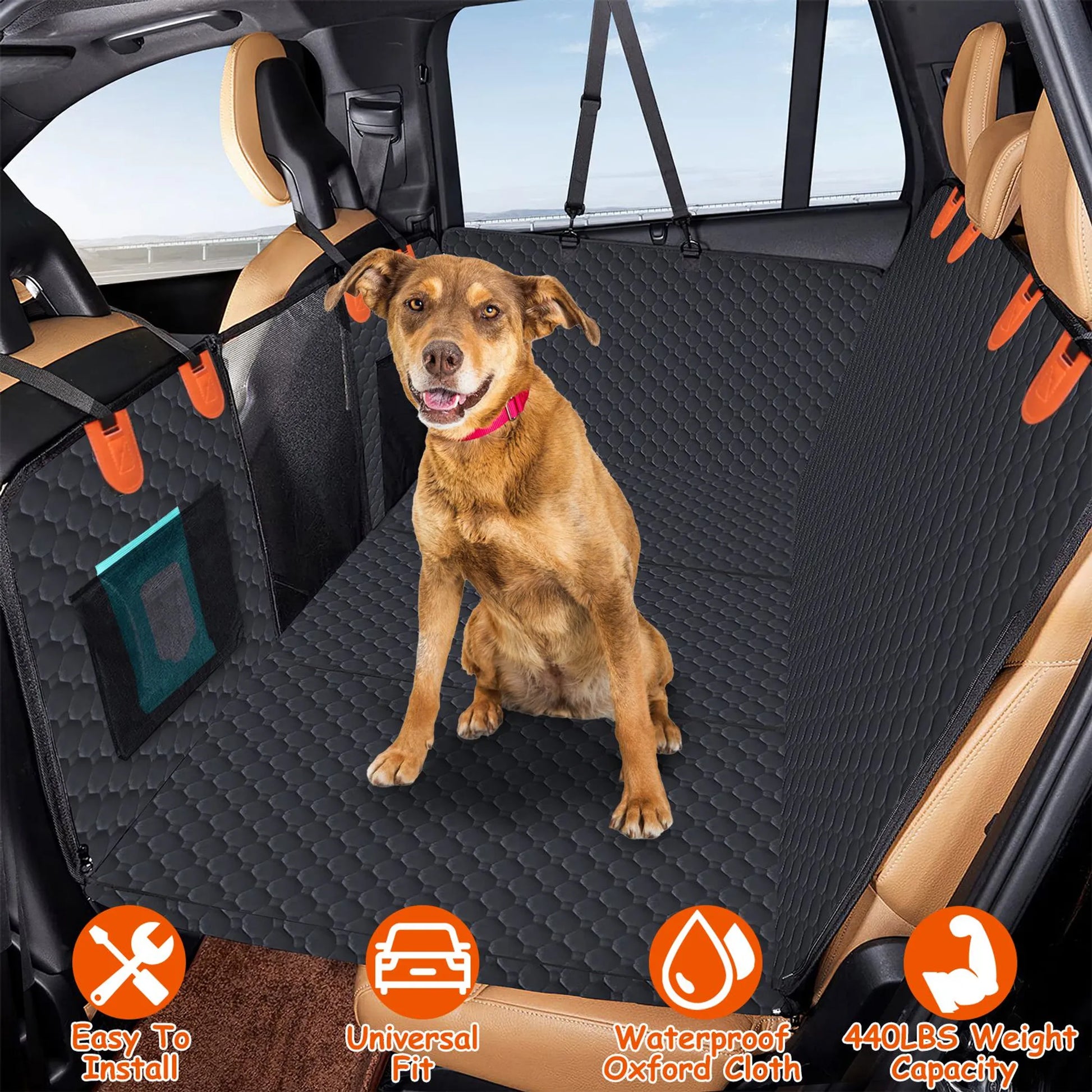 Dog sitting on a black car seat cover with orange straps in a vehicle.
