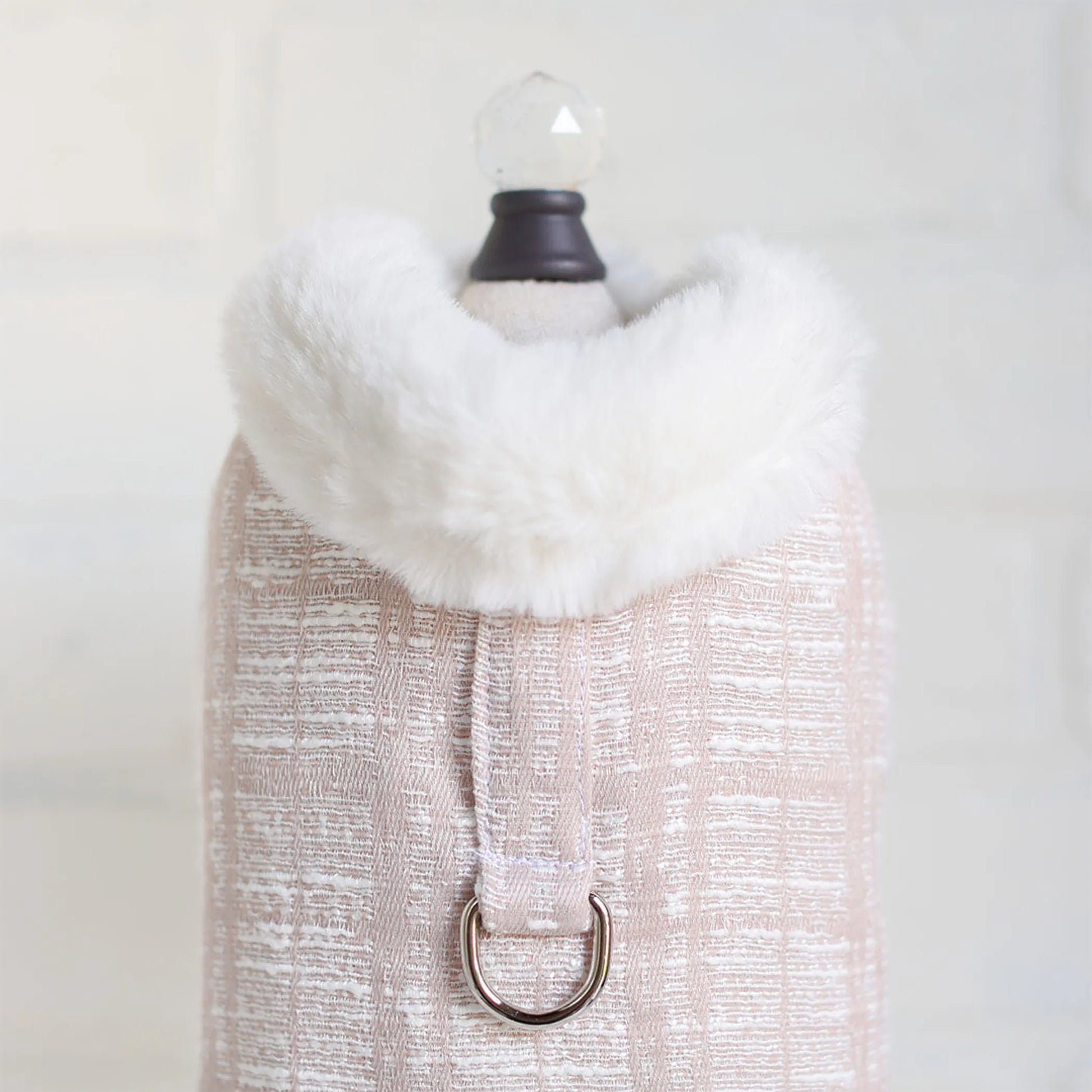 White fur scarf on a mannequin with a plain background
