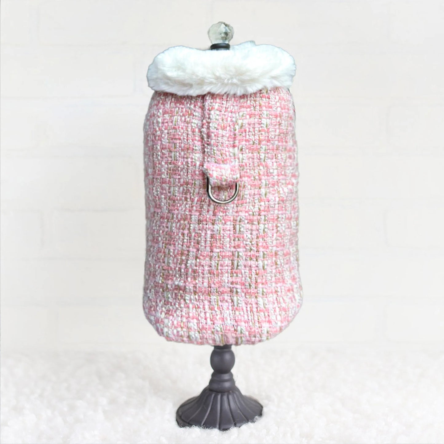 Mannequin wearing a pink tweed dress with white fur trim on a white background
