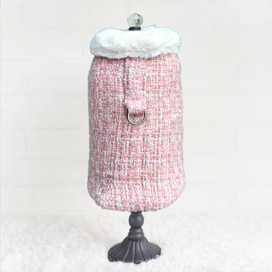 Mannequin wearing a pink tweed dress with white fur trim on a white background
