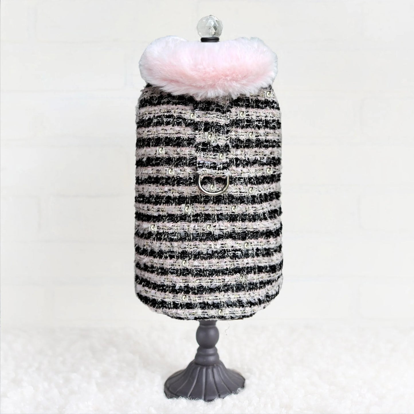 Black and white striped dress on a mannequin with pink fur trim against a white background