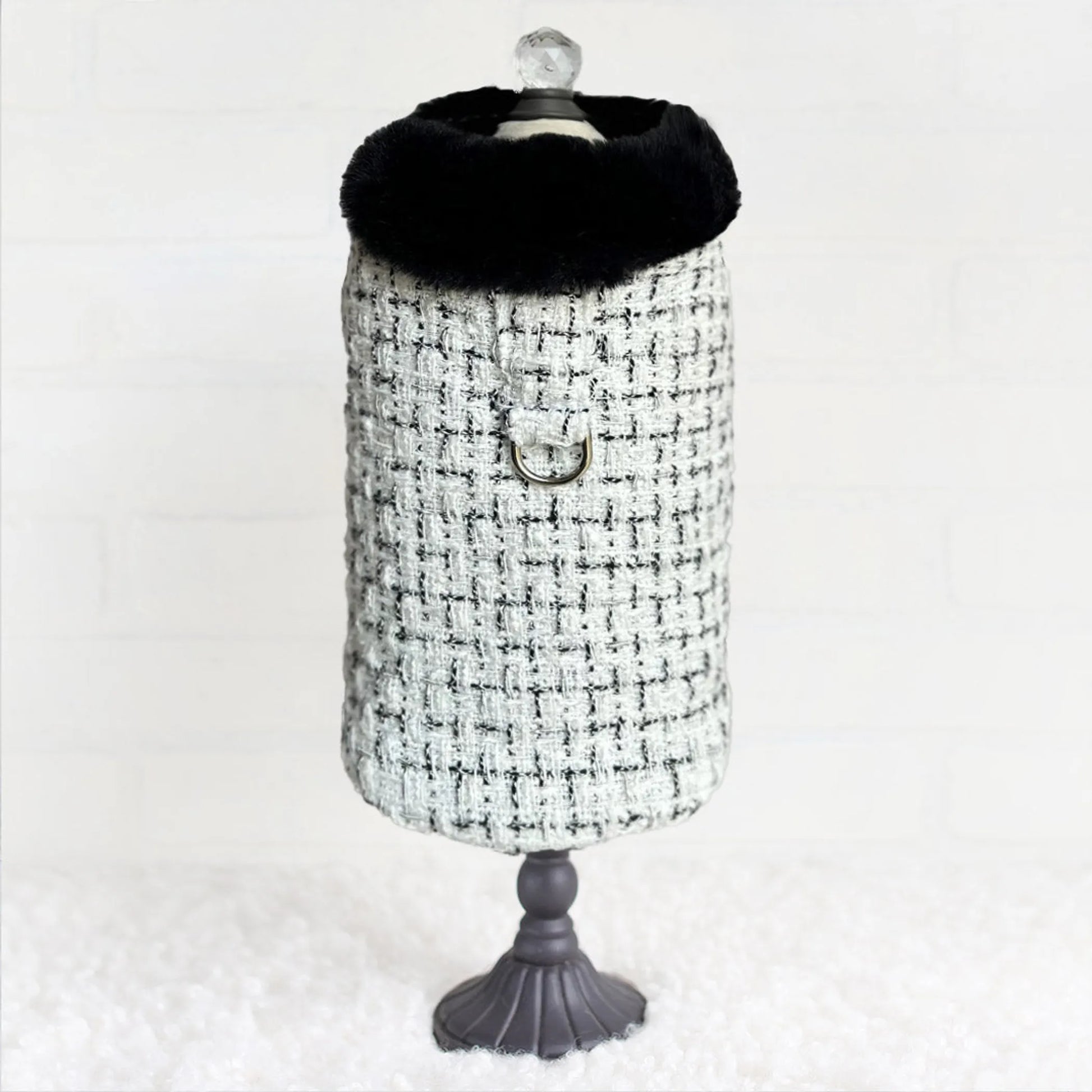 Black and white checkered dog coat on a mannequin with a plain background