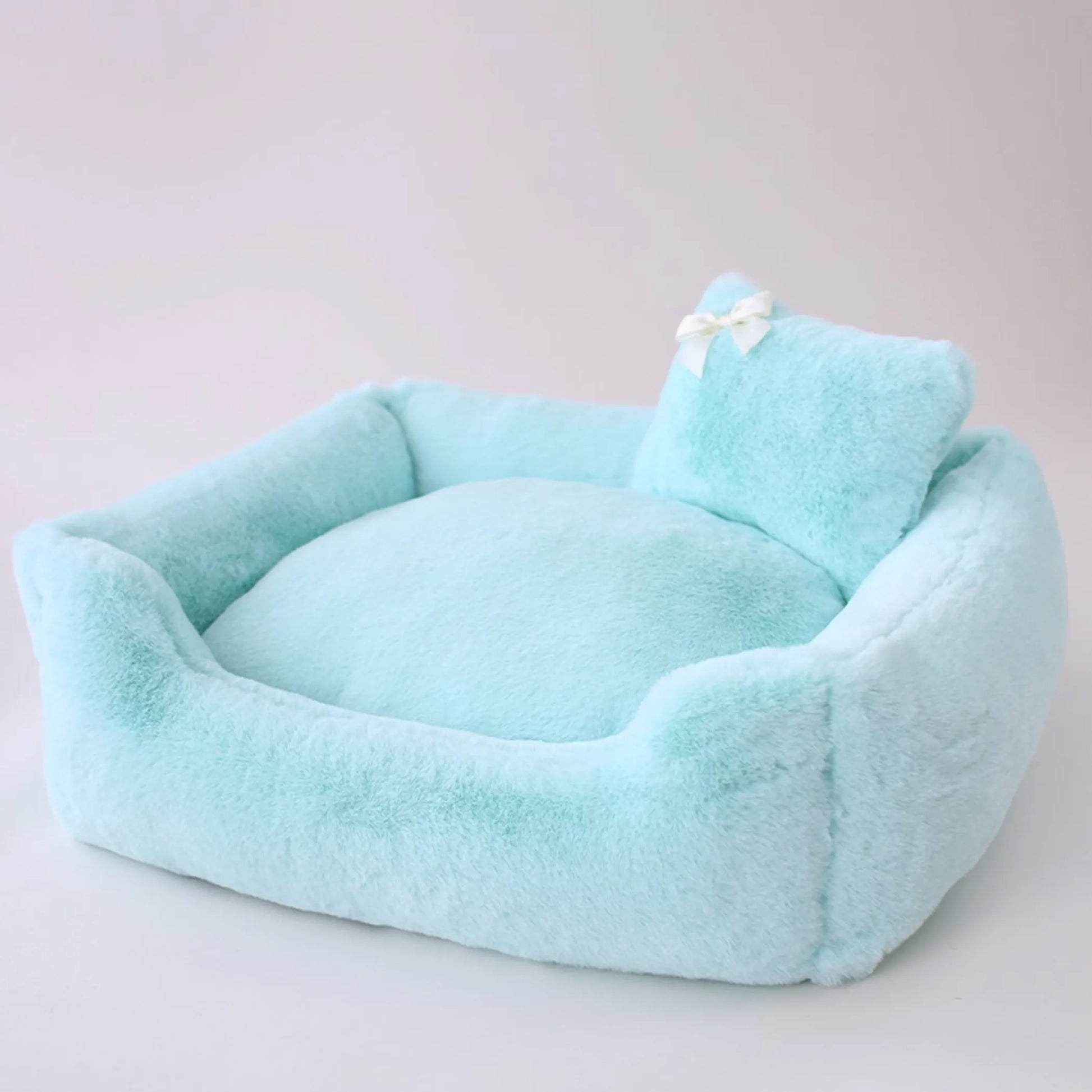 Light blue pet bed with a pillow on a light gray background