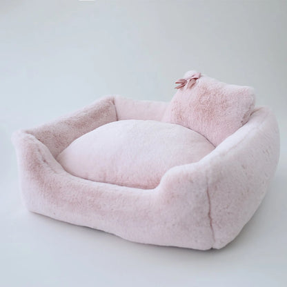 Pink pet bed with a pillow on a light gray background